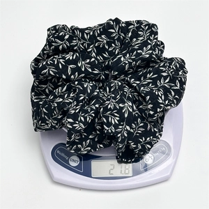 Detailed view of wide ink print scrunchie on scale showing weight of 21.8 grams