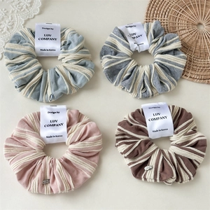 Set of four striped knit scrunchies in pastel blue, grey, pink and brown colors