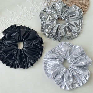 Three-piece set of large metallic laser scrunchies in silver and black with pleats