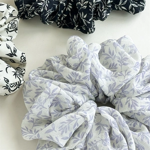 Detail of high-elasticity scrunchies with ink floral patterns in purple and black