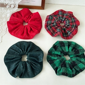 Set of four Christmas hair scrunchies featuring red and green plaid and solid pleated designs