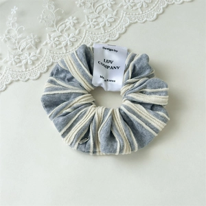 Detailed close-up of a blue and white striped knit scrunchie with a Made in Korea tag
