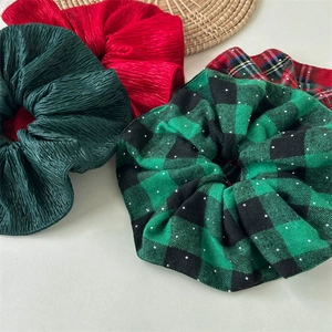 Detail of Christmas scrunchies with green pleats, red pleats, and classic plaid patterns