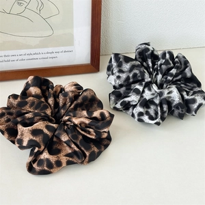 Elegant leopard print silk scrunchies in brown and grey tones for a stylish ponytail look