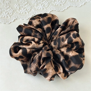 Detailed view of large leopard print scrunchie featuring soft satin texture and fold design