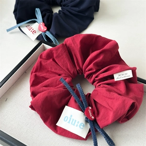 Detail of dark red and navy blue scrunchies with denim bows and heart charms