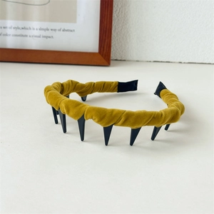 Detail of mustard yellow velvet headband with toothed inner grip and ruched fabric texture
