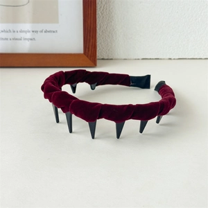 Detail view of burgundy velvet headband showing black anti-slip plastic teeth texture