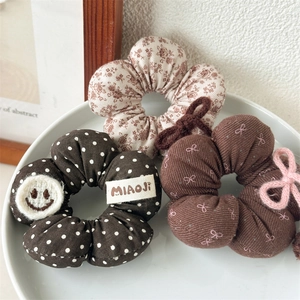 Dreiteiliges Set aus floralen und gepunkteten Haargummis in herbstlichen Brauntönen