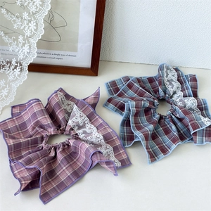 Close-up of vintage plaid scrunchies with white lace edges in soft pink and blue tones