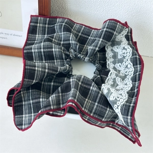 Detail of vintage black and white plaid hair scrunchie with red edges and lace bow decoration