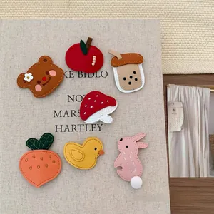 Flat lay of cute leather bear and rabbit hair clips on a textured background