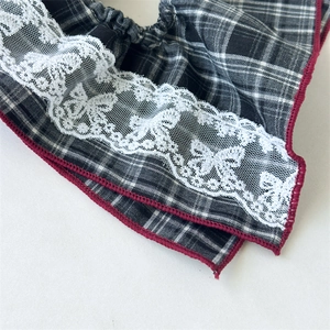 Close-up of vintage plaid hair scrunchie with lace butterfly detail and red edge