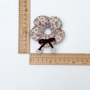 Detailansicht Haargummi mit Blumenmuster, Schleife und Bommeln, Größe ca. 9 cm