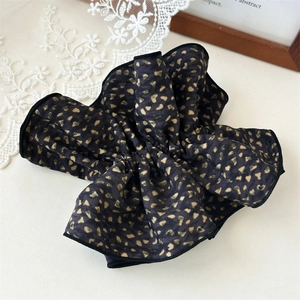 Elegant black scrunchie with gold floral patterns and high-quality pleated fabric detail