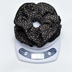 Detail shot of a large leopard print scrunchie showing its weight of 27.9g on a digital scale