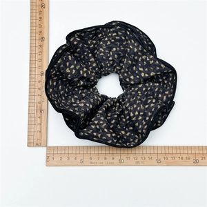Macro top view showing a 15cm oversized leopard print fabric scrunchie on measuring scale
