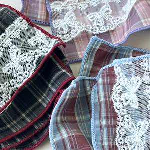 Close-up of vintage plaid hair tie fabric with delicate white lace butterfly appliques