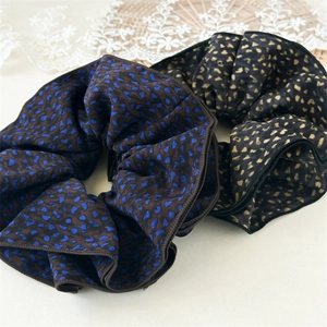 Detailed macro view of leopard print chiffon scrunchies with elegant overlock edges