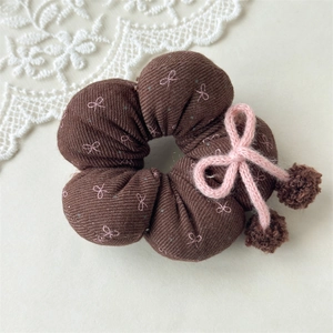 Nahaufnahme von Blumen-Haargummi mit rosa Strickschleife und Plüsch-Pompons Details
