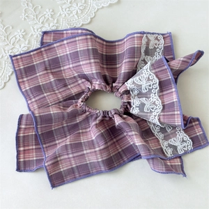Detail of purple plaid hair scrunchie with delicate white floral embroidery lace edges