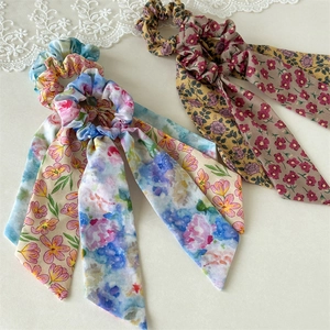 Detailed view of floral chiffon scrunchies with long ribbons and elegant soft pleats