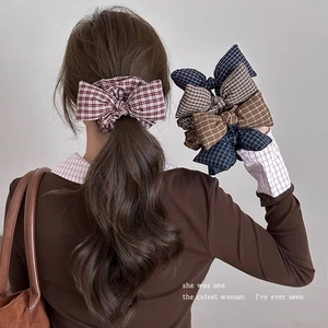 Close-up of British style plaid bow scrunchies in various vintage colors for women