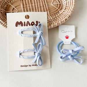 Dettaglio del set di fermagli e elastici per capelli con fiocchi in tessuto blu chiaro