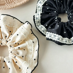 Satin polka dot scrunchies with white lace edges in cream and black colors