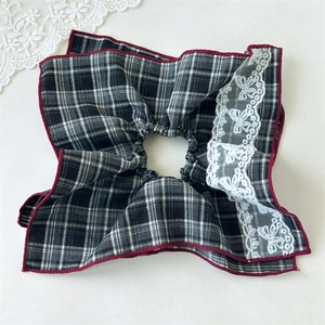 Detail of vintage black and white plaid scrunchie with red stitching and butterfly lace