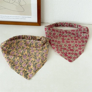 Close-up of floral cotton headbands in yellow and red with elastic band detail