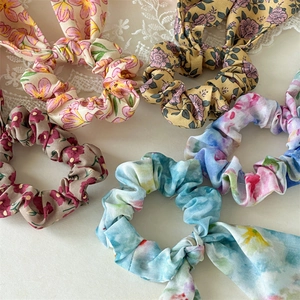 Close-up of floral print scrunchies with streamers in assorted pastel colors