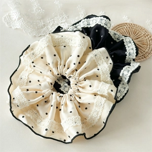 Detailed view of large satin scrunchies with polka dots and delicate white lace edges