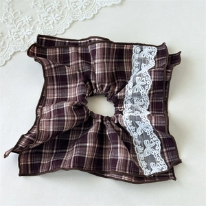 Macro shot of dark brown plaid scrunchie with delicate white floral lace trim details