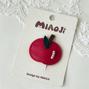 Detailed view of handmade red apple faux leather BB hair clip with decorative beads