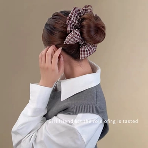 Detail of vintage red plaid bow scrunchie worn on a low ponytail for a preppy look