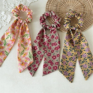 Detailed set of three floral print scrunchies with ribbons in soft summer colors