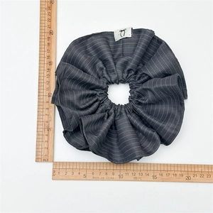 Detailed size measurement of striped grey fabric scrunchie with brand logo tag