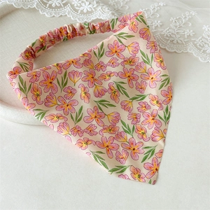 Detailed macro view of apricot floral triangle headscarf with elastic band and lace decor