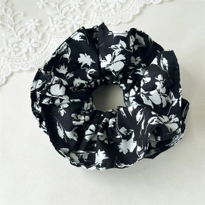 Gros plan du chouchou à motif floral noir et blanc avec texture plissée élégante