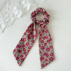 Detailed view of floral scrunchie with long ribbons in grey and purple oil painting style