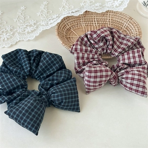 Detail of vintage plaid scrunchies with bow design on white lace and woven basket background