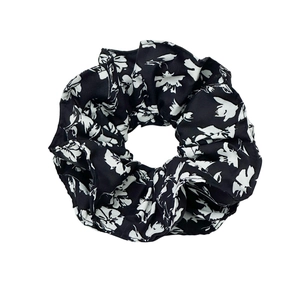 Chouchou élégant surdimensionné avec motif floral blanc sur tissu satin noir