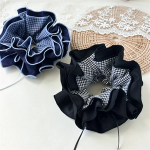 Detailansicht von doppelseitigen Schleifen-Scrunchies mit Karomuster und Rüschendetails