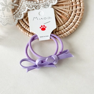 Dettaglio di elastici per capelli viola con fiocchi per bambine, accessori elastici