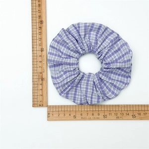 Detailed top view of a purple and white plaid scrunchie measuring approximately 15cm wide