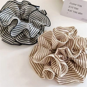Striped oversized scrunchies in black, white, and brown fabrics for elegant ponytails