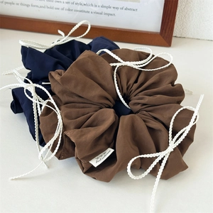 Blue and brown bow scrunchies with white braided ties in a soft minimalist style