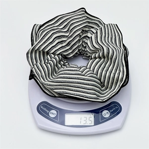 Close-up of black and white striped fabric scrunchie hair tie weighing 13.5 grams