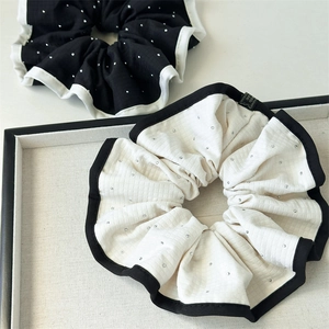 Détail de chouchous en tissu quadrillé avec paillettes argentées et étiquette à la main